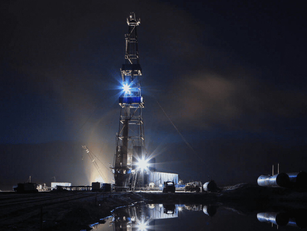 Lit oil platform under night sky